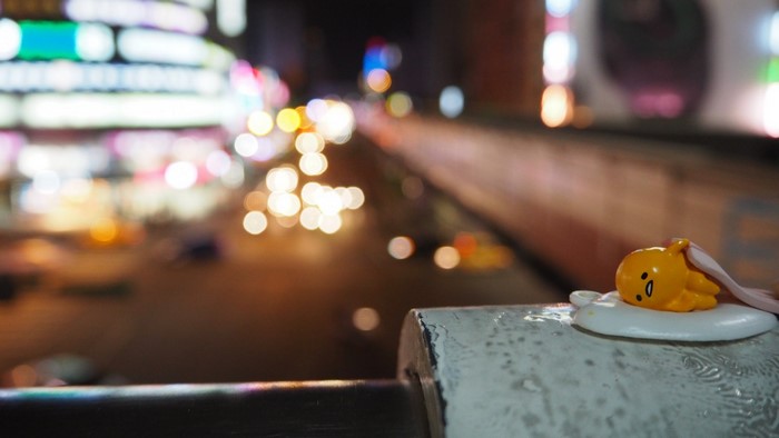 Gudetama figurine on a railing at night in Taiwan