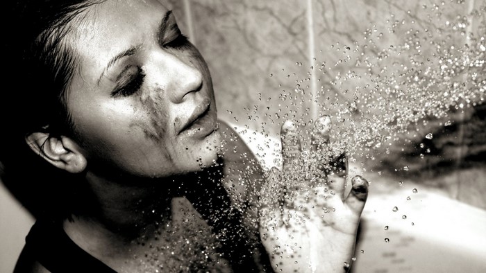 Monochrome portrait of a woman in shower with water drops