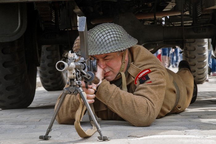 Soldier in uniform aiming a machine gun