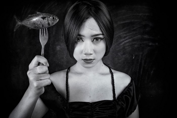 Woman holding a fish on a fork