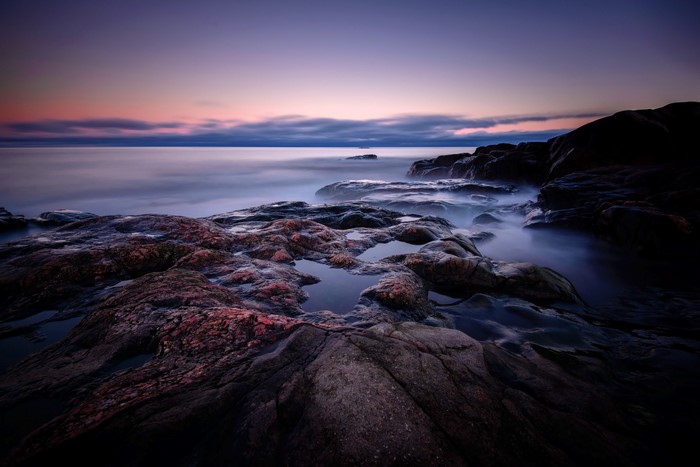 Rocky coast at dusk with ocean waves