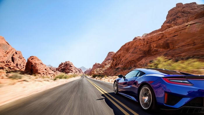 Blue Acura NSX driving on a desert road