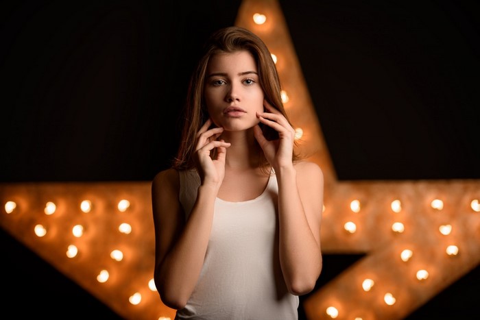 Woman posing in front of a star-shaped light fixture