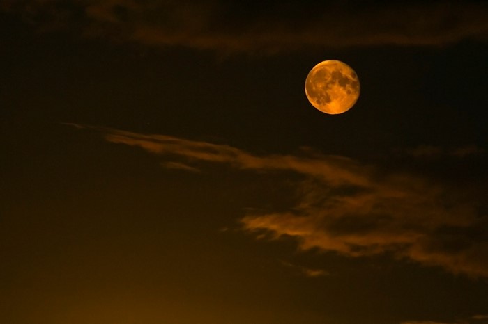Full moon in the night sky with clouds