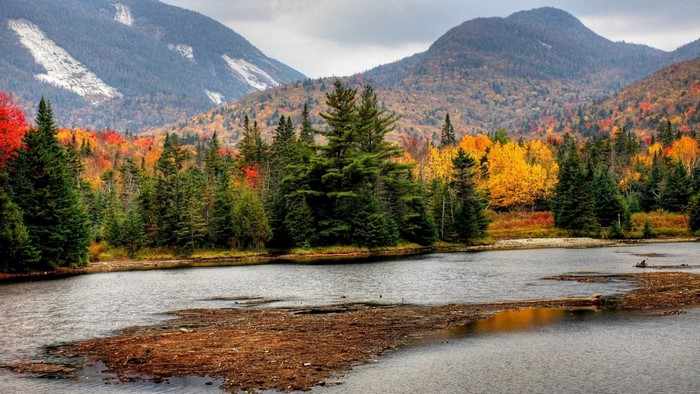 Autumn forest and mountains reflected in a lake