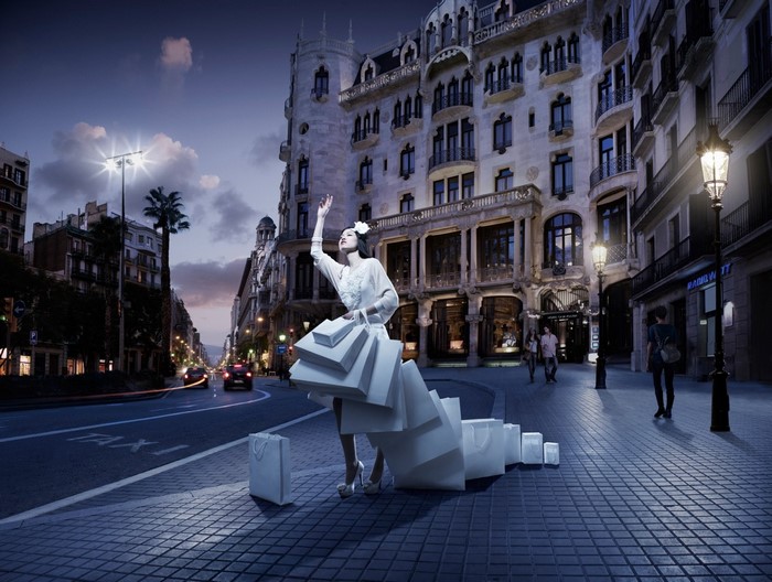 Woman with shopping bags hailing a taxi at night