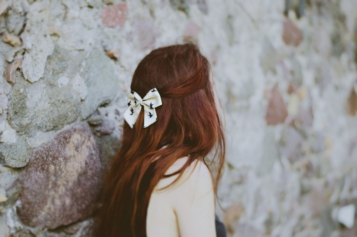 Woman with red hair and a bow in her hair