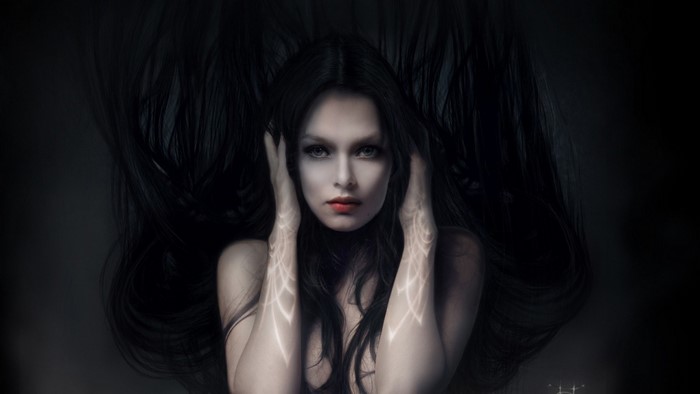 Woman with long black hair and glowing tattoos