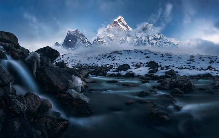 Snowy mountains with a river and waterfall