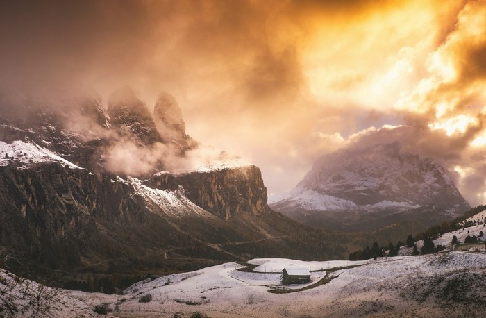 Snowy mountains with a cabin at sunrise