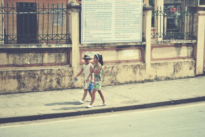 Two girls walking on a sidewalk in Asia
