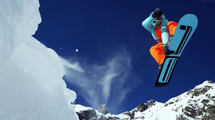 Snowboarder performing a jump in the mountains