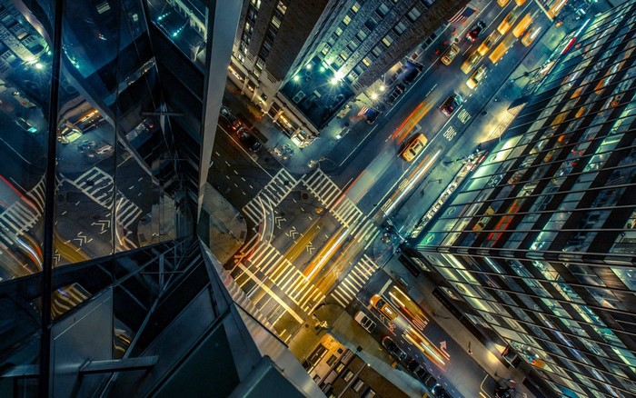 Aerial view of a city intersection at night with light trails