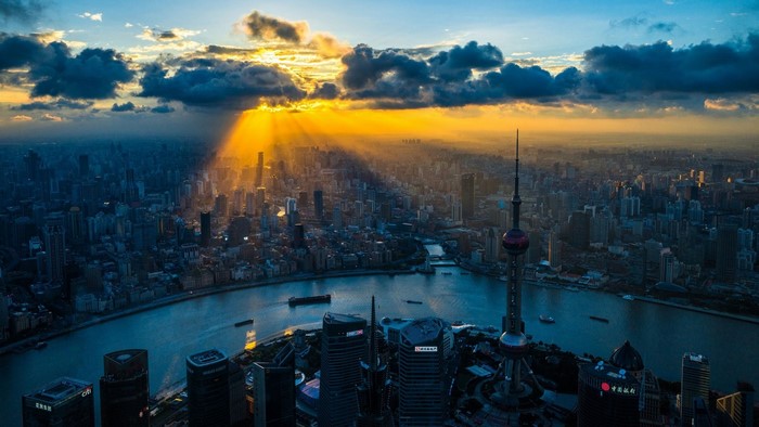 Shanghai cityscape at sunset with sunbeams over the city