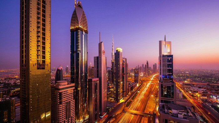 Dubai cityscape at sunset with illuminated skyscrapers