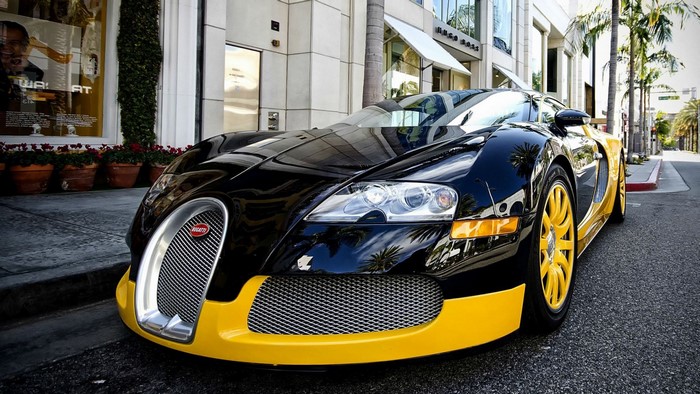 Black and yellow Bugatti Veyron parked on a street