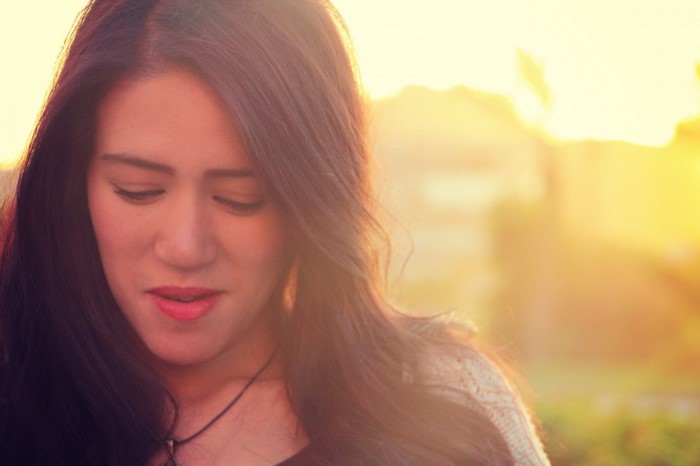 Woman with long brown hair in sunlight
