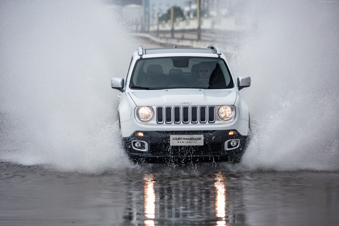 White Jeep Renegade driving through water spray