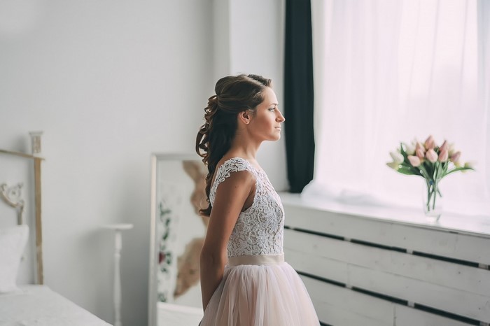 Bride in a wedding dress by the window