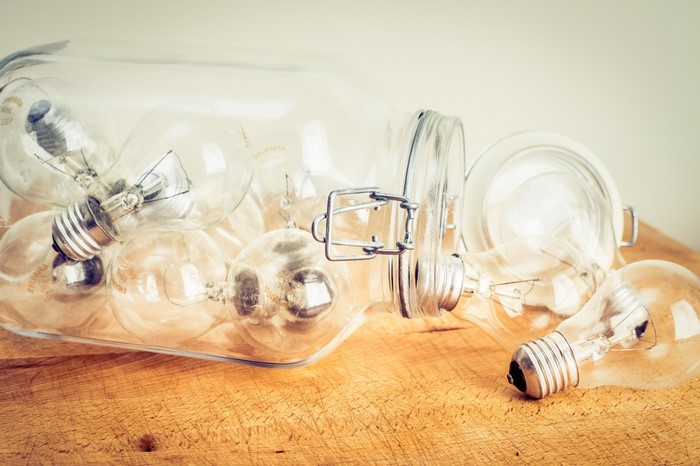 Lightbulbs in a glass jar on a wooden surface