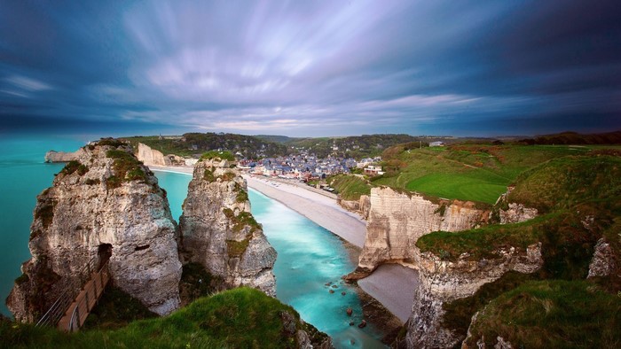 Etretat cliffs and beach with town in Normandy, France