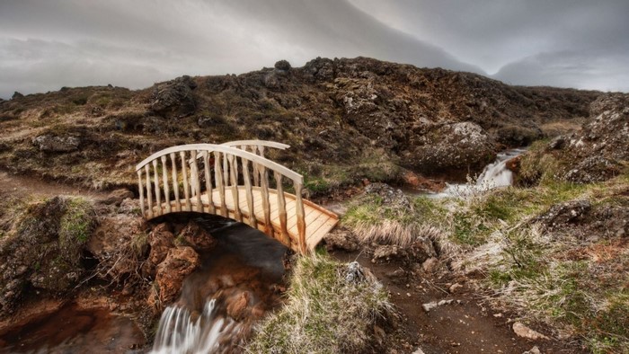 Wooden bridge over a stream in a rocky landscape