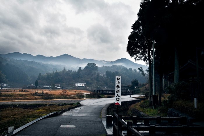 Road leading to misty mountains in a rural village
