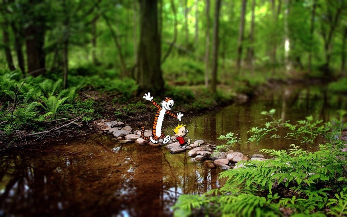 Calvin and Hobbes crossing a stream in a forest