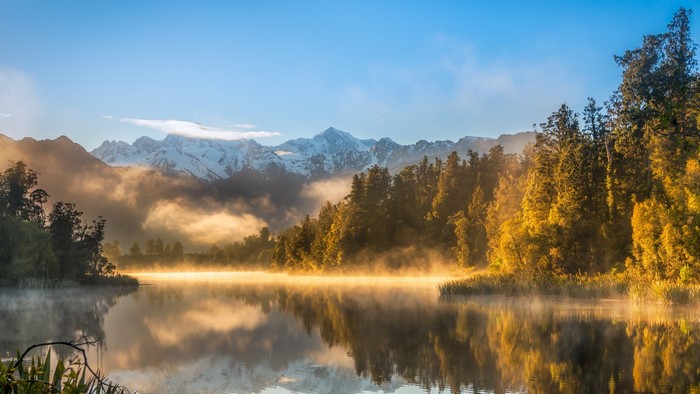 Misty Lake Reflection with Snow-Capped Mountains and Forest