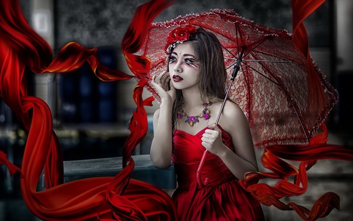 Woman in red dress with umbrella and red ribbons