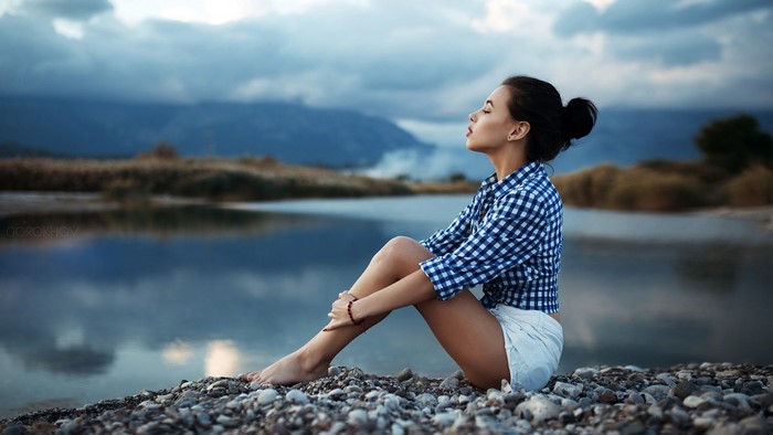 Serene Portrait of Woman Sitting by Calm Lake