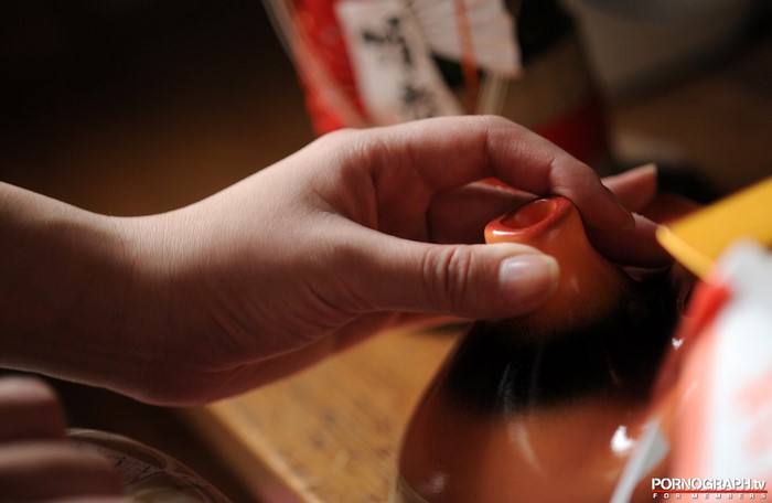 Hand touching an orange and black object
