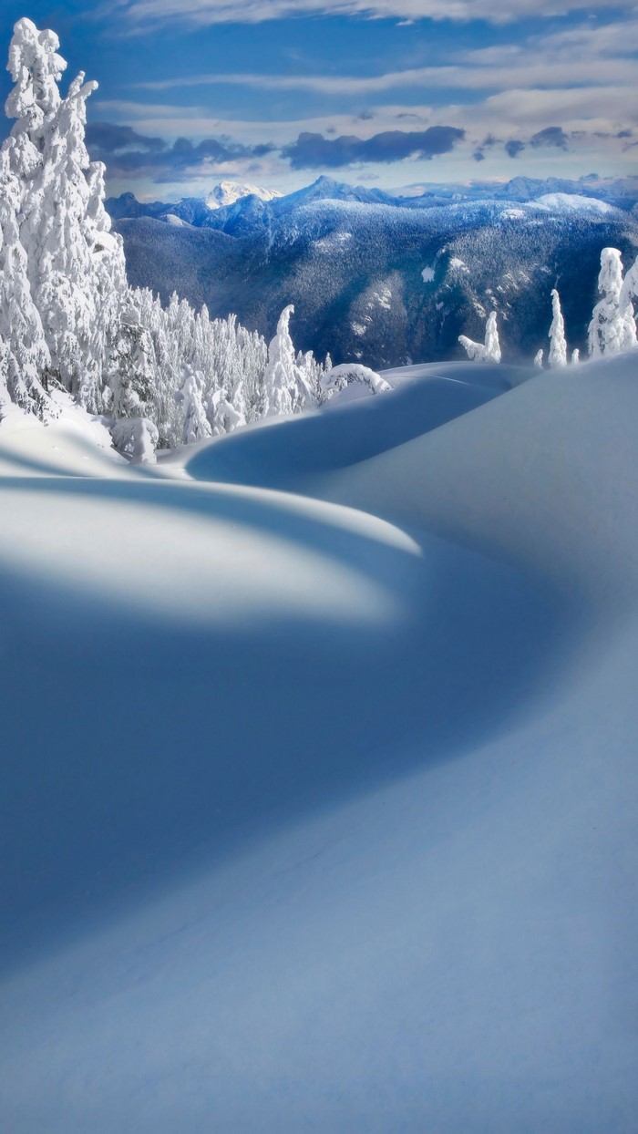 Snowy mountain landscape with blue sky and clouds
