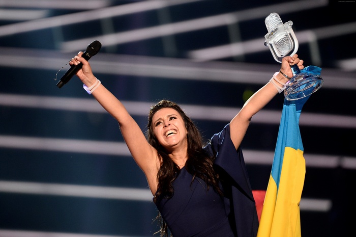 Jamala from Eurovision 2016 holding microphone and trophy