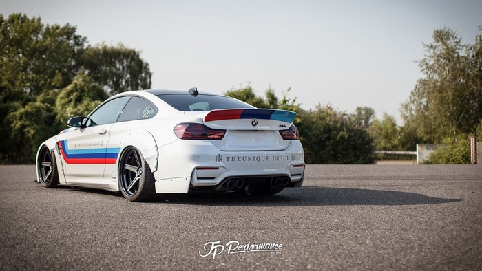 White BMW M4 with custom tuning and racing stripes