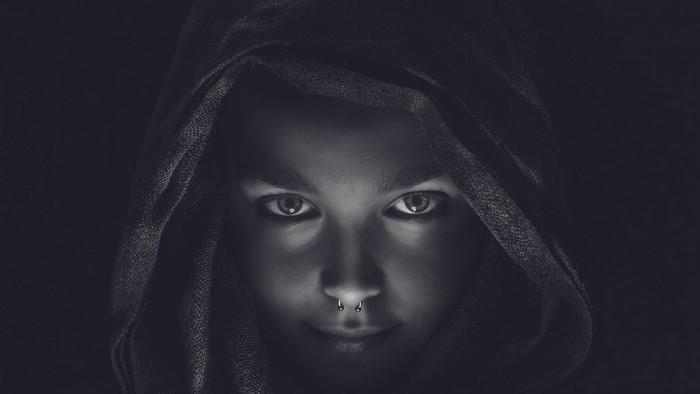 Monochrome portrait of a woman with a nose ring wearing a hood