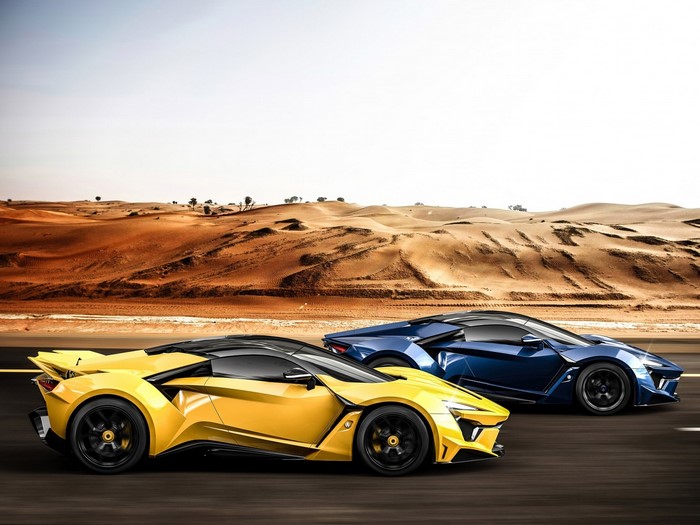 Yellow and blue sports cars driving on a desert road