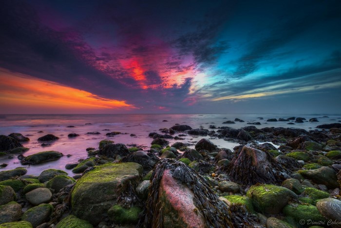 Rocky shore at sunset with colorful clouds over the ocean