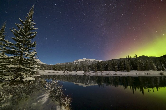 Snowy Landscape with Aurora Borealis and Mountain Reflection