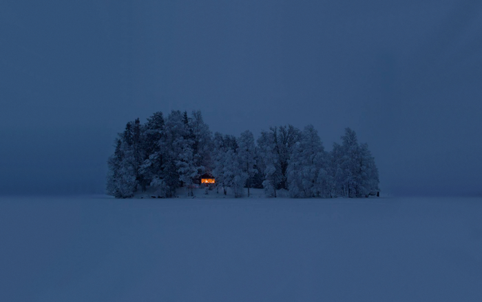Cabin in a snowy forest at dusk