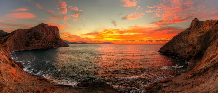 Sunset over a rocky bay with cliffs