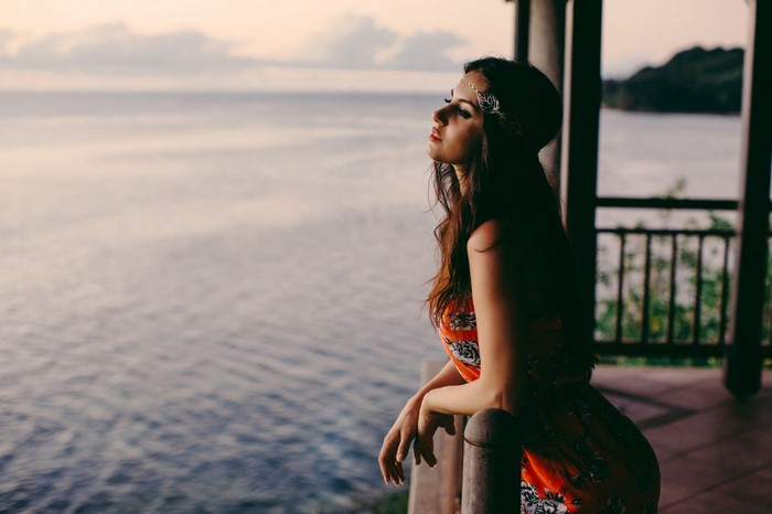 Woman in Orange Dress Gazing Over Calm Sea