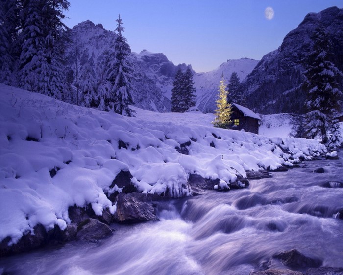 Winter mountain landscape with a stream and a cabin