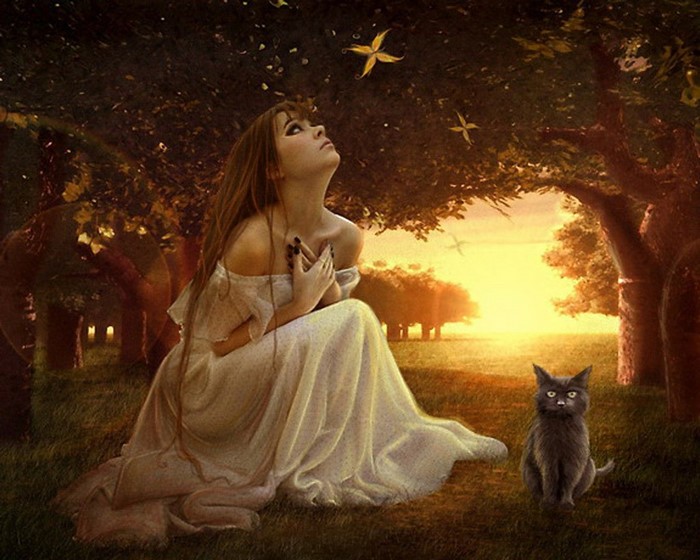 Woman in white dress with cat at sunset