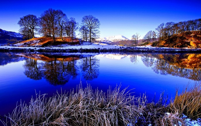 Winter landscape with snow-covered mountains and a reflective lake