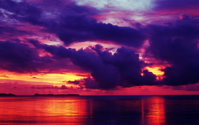 Dramatic sunset over the ocean with purple and red clouds