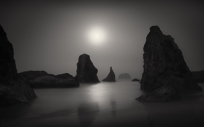 Monochrome seascape with rock formations in fog