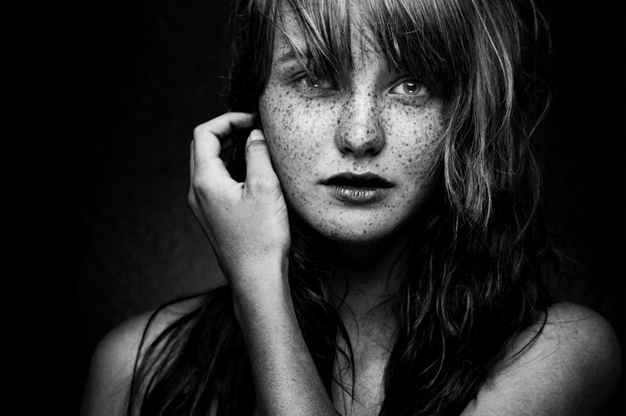 Monochrome portrait of a young woman with freckles