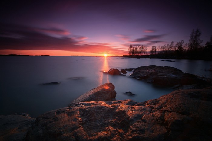 Sunset over a rocky coast with calm water