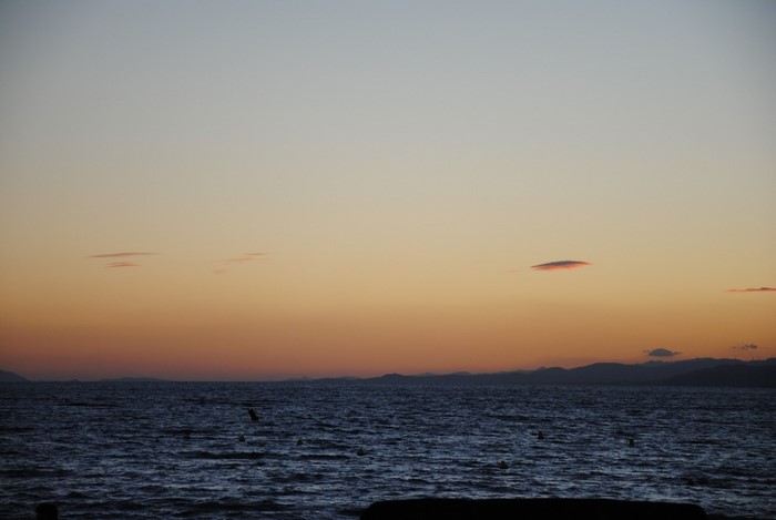 Sunset over the ocean with distant mountains